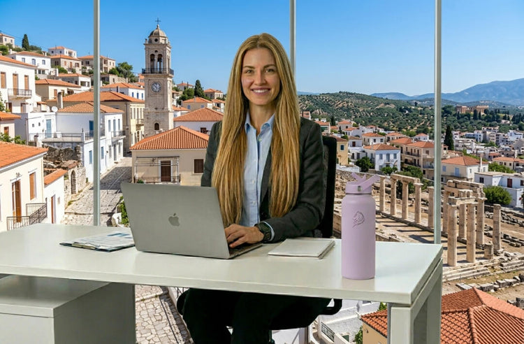Coolnmore Lavender θερμος νερου 1 λιτρου με καλαμακι. Woman working on a laptop with a scenic town view in the background
