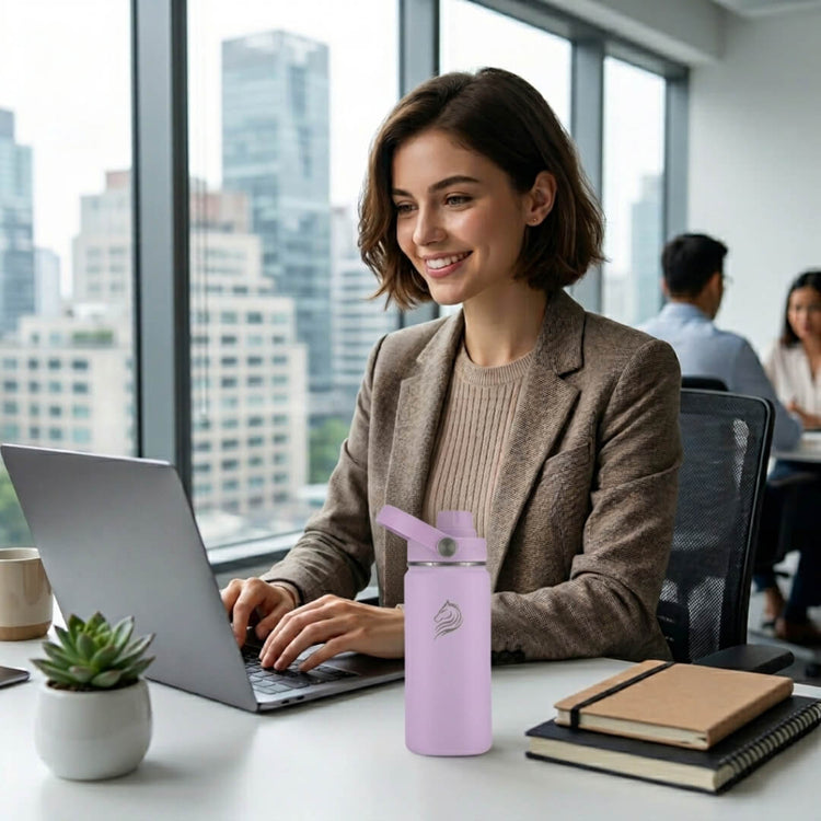 Coolnmore Lavender 350ml παιδικο παγουρι θερμος. Woman working on a laptop at a desk with a cityscape view and her water bottle