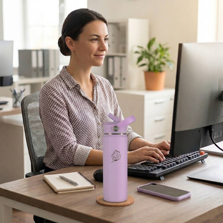 Coolnmore Lavender παγουρι θερμος νερου 750ml. Woman sitting at a desk in an office with a purple water bottle on the desk.
