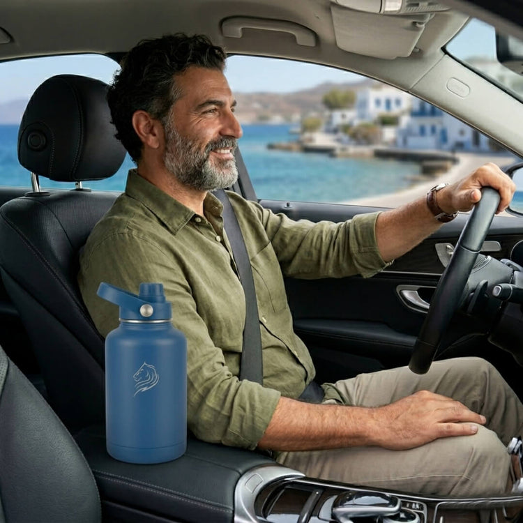 Man driving a car with a blue water bottle on the passenger seat, scenic view outside. Οδηγος στο αυτοκινητο με το Coolnmore Denim παγουρι θερμος 1.5lt  