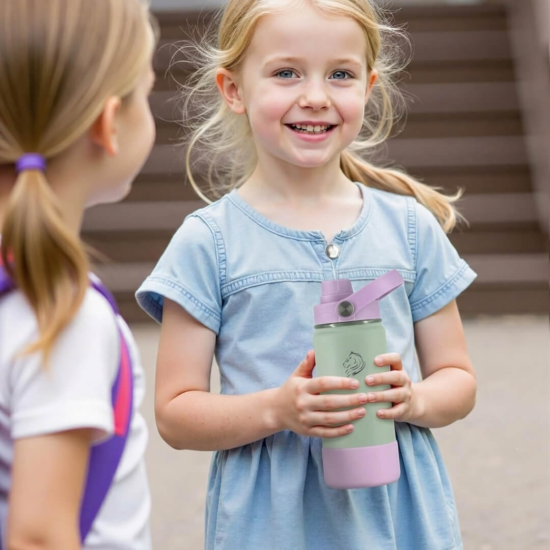 Young girl holding a green and pink water bottle, standing next to another child Coolnmore Mino παιδικο παγουρι θερμος νερου 350ml. 